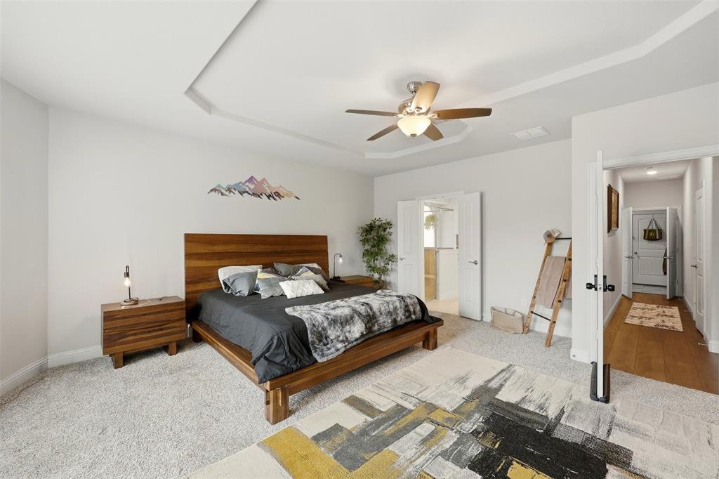 418 Crestview Drive Midlothian, TX 76065 - Photo 15 of 39 Primary Bedroom featuring light colored carpet, a raised ceiling, and ceiling fan