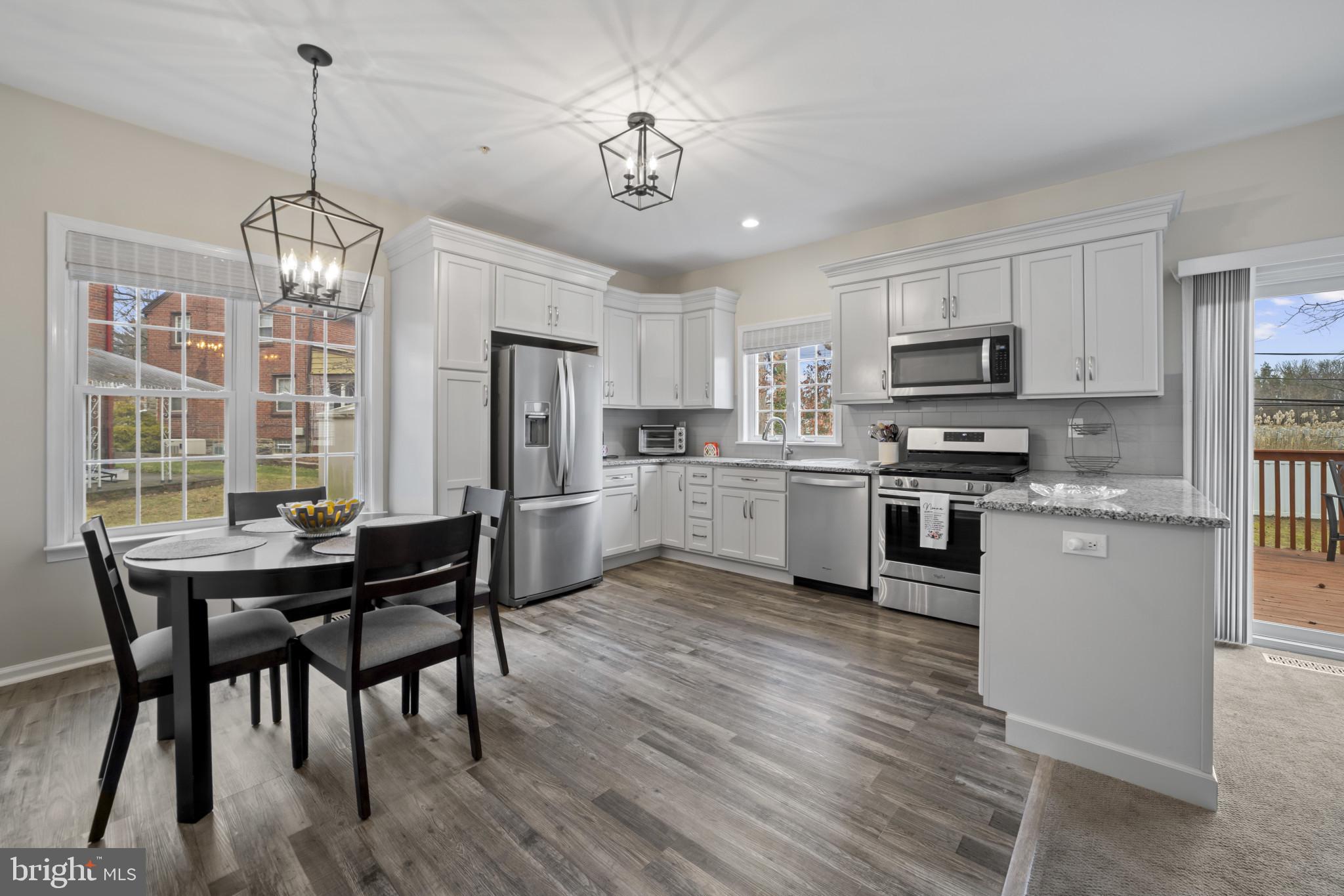 211 South Norwinden Drive Springfield, PA 19064 - Photo 13 of 38 a kitchen with microwave a stove a table and chairs
