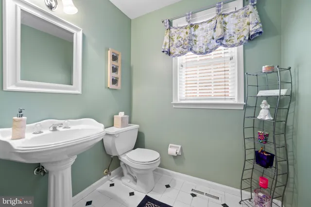 a bathroom with a sink mirror and toilet