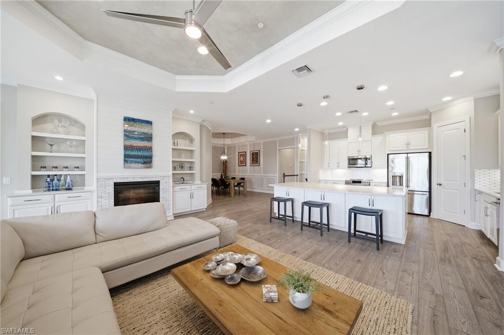 9658 Montelanico Loop, Unit 201 Naples, FL 34119 - Photo 2 of 46 a living room with furniture fireplace and flat screen tv