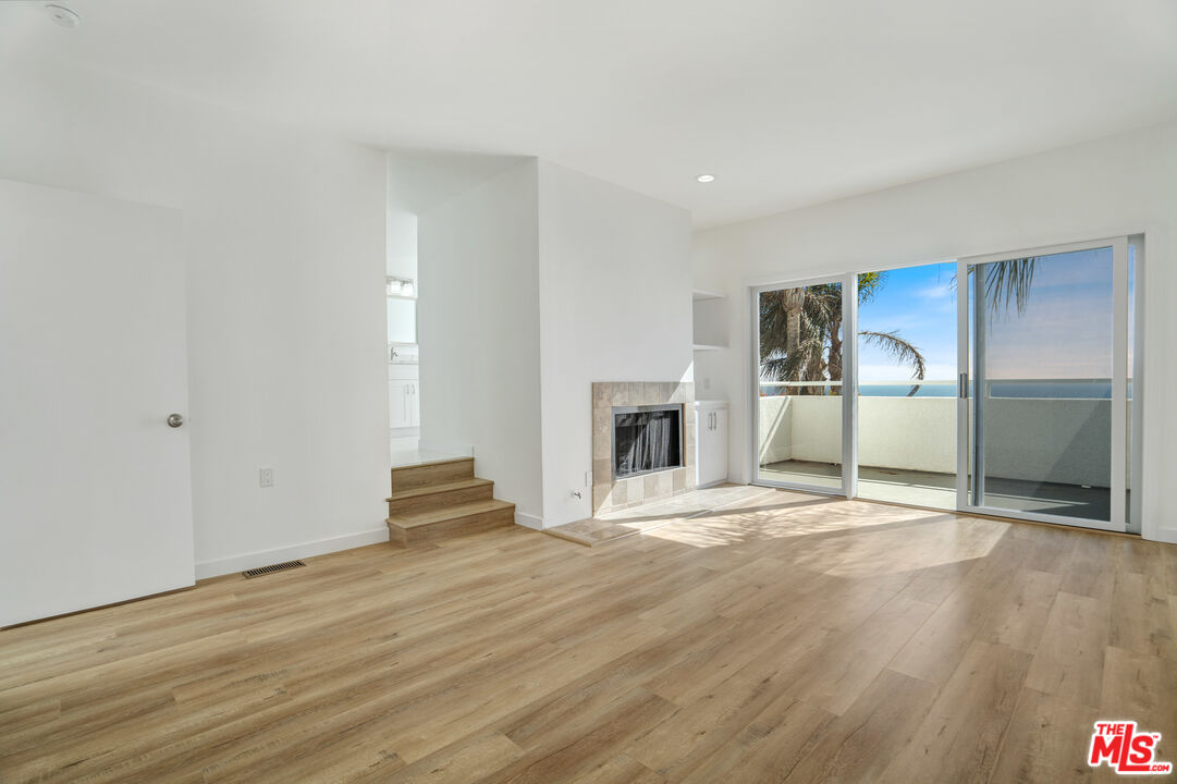 31246 Bailard Road Malibu, CA 90265 - Photo 18 of 31 a view of an empty room with wooden floor and a fireplace