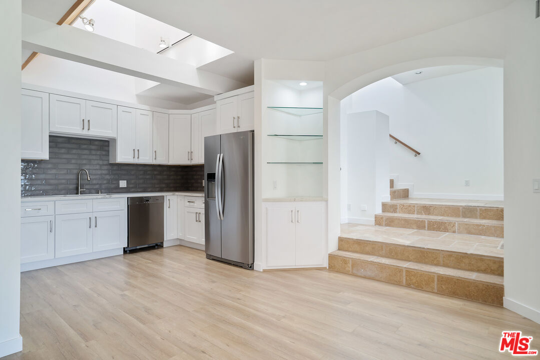 31246 Bailard Road Malibu, CA 90265 - Photo 6 of 31 a kitchen with a refrigerator and white cabinets