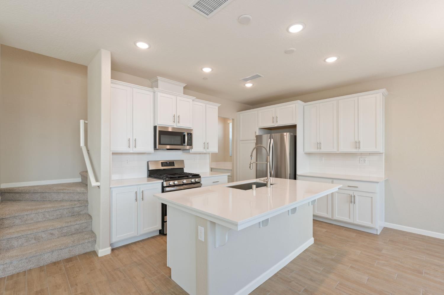 1109 Royalty Way West Madera, CA 93636 - Photo 12 of 47 a kitchen with refrigerator cabinets and wooden floor