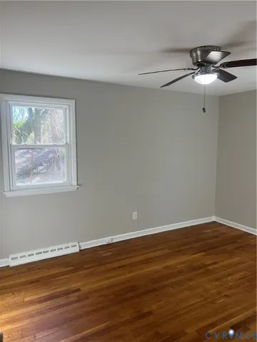 a view of room with wooden floor and fan