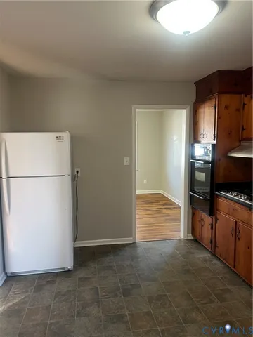 a view of kitchen with refrigerator and cabinets