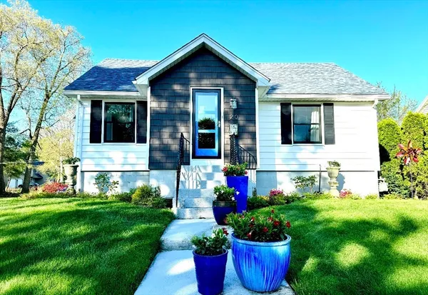 a front view of a house with a garden and plants