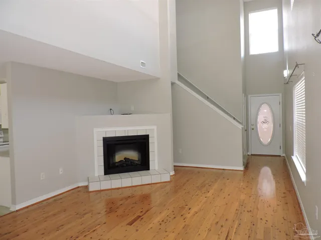 a living room with wooden floor and a fireplace