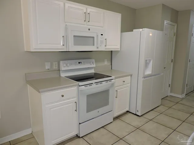 a kitchen with white cabinets and white appliances
