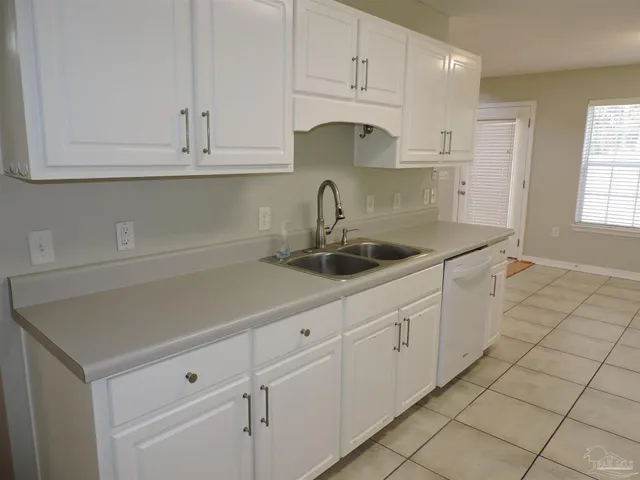 a kitchen with white cabinets and a sink