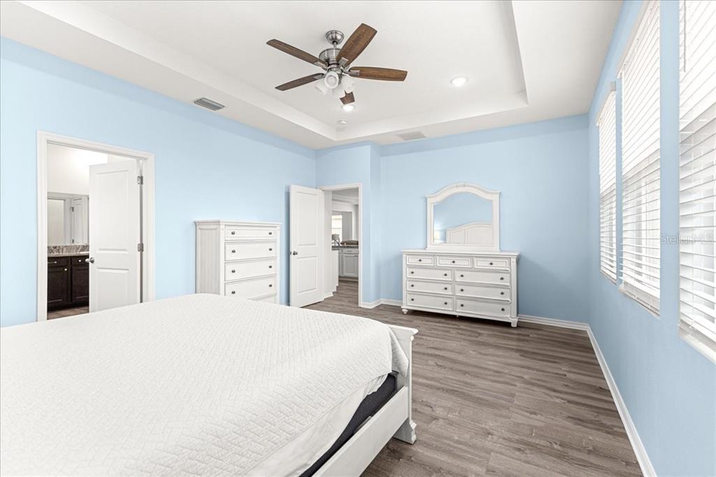 5851 Southwest 85th Place Ocala, FL 34476 - Photo 19 of 57 a spacious bedroom with a large bed a chandelier and dresser
