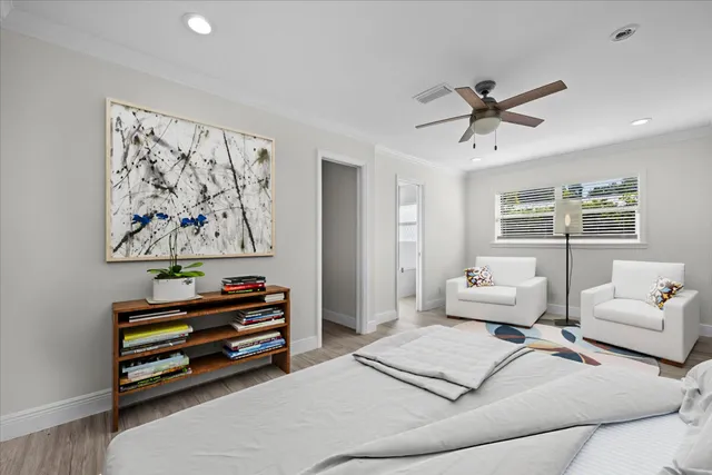an empty room with wooden floor fan and windows