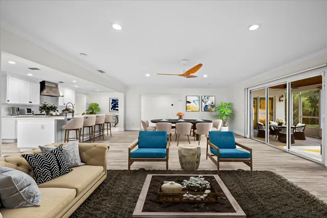 a spacious bedroom with a bed a couch and a dresser with wooden floor