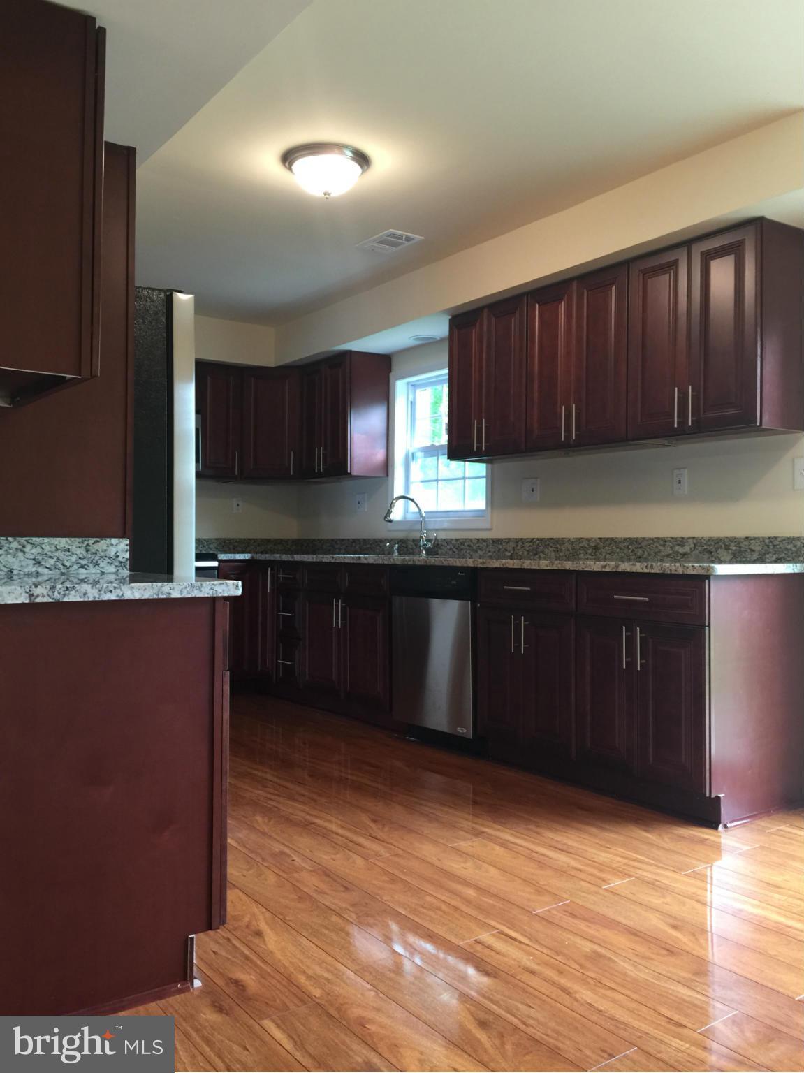 a kitchen with granite countertop wooden cabinets and a granite counter top