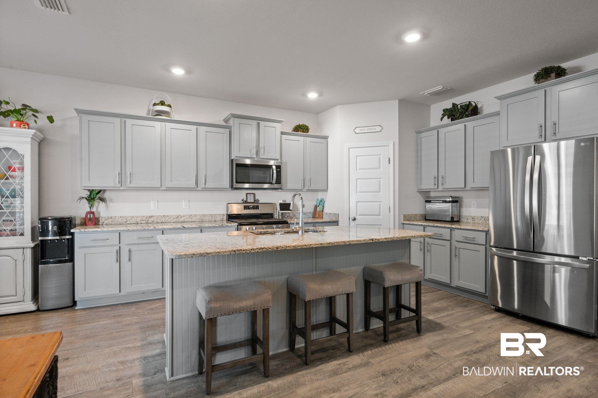 24891 Spectacular Bid Loop Daphne, AL 36526 - Photo 16 of 51 Kitchen with stainless steel appliances, a breakfast bar area, sink, and a center island with sink