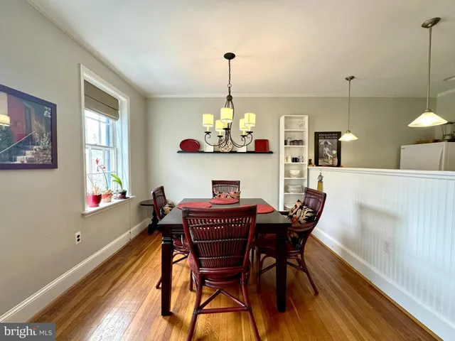 a dining room with furniture a chandelier and wooden floor