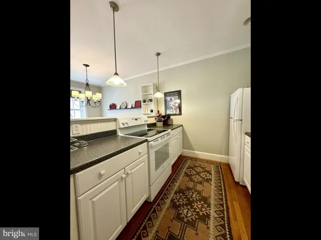 a kitchen with white cabinets and white appliances
