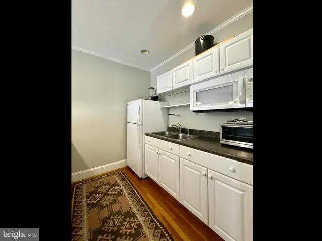 a kitchen with a sink a refrigerator and cabinets