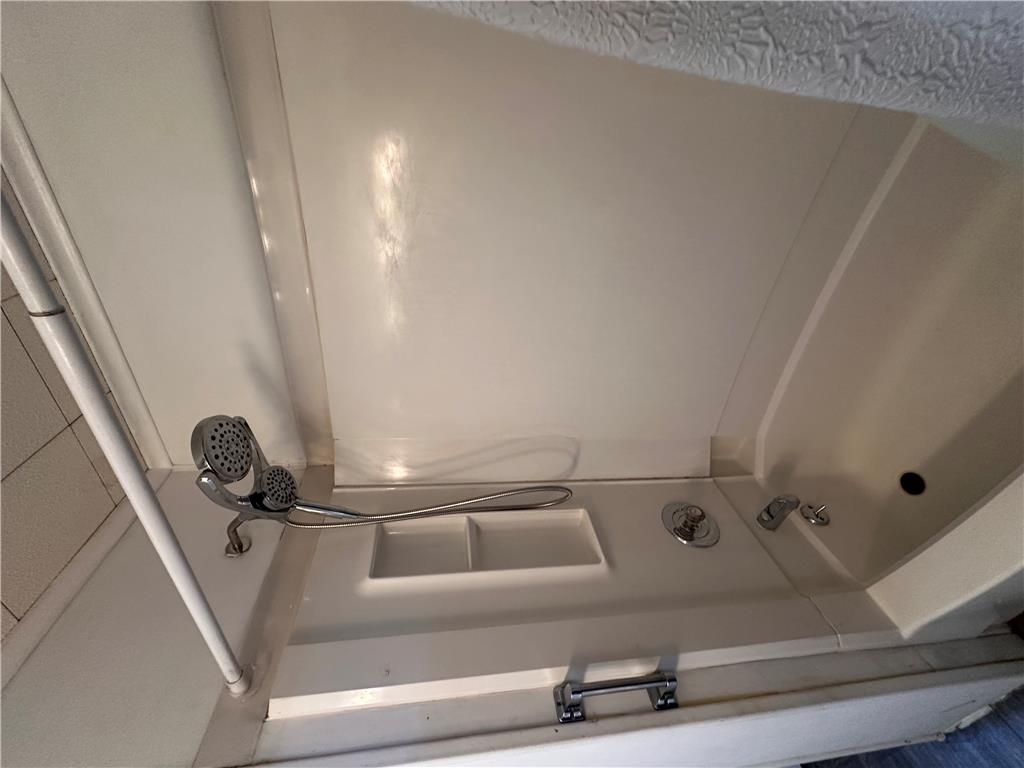 5128 3rd Street Whitehall, PA 18052 - Photo 22 of 26 A compact shower stall offers efficient bathing with a hand-held showerhead and built-in shelving.