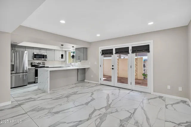a kitchen with stainless steel appliances a refrigerator sink and microwave