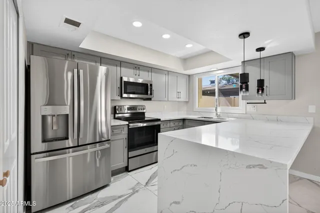 a kitchen with stainless steel appliances kitchen island a sink a stove and a refrigerator