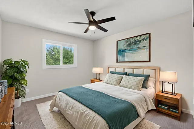 an empty room with a window and a fan