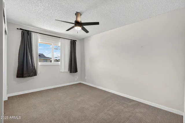 a view of a livingroom with a ceiling fan & entryway