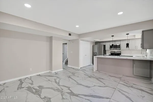 a large white kitchen with stainless steel appliances granite countertop a stove and a sink
