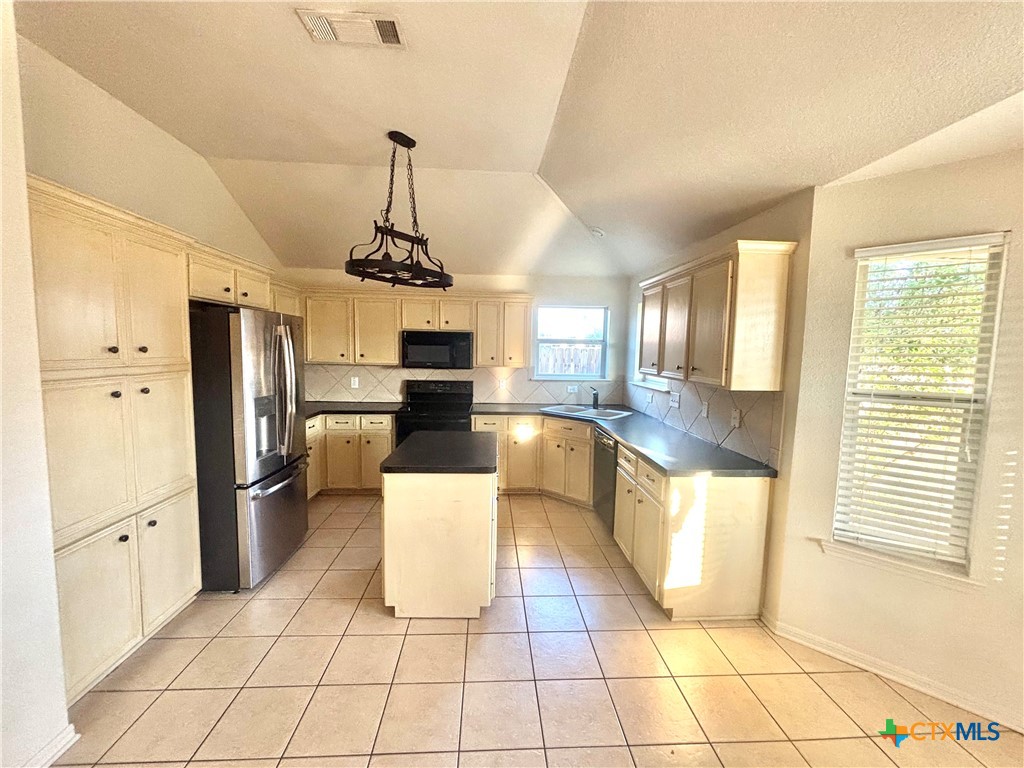 3610 Armstrong County Court Killeen, TX 76549 - Photo 7 of 29 a large kitchen with stainless steel appliances a stove a sink dishwasher and a refrigerator with wooden floor