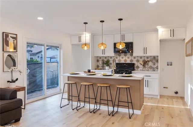 a kitchen with stainless steel appliances kitchen island granite countertop a stove a sink and a refrigerator