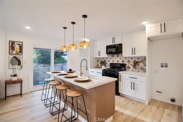 a kitchen with sink a stove and chairs