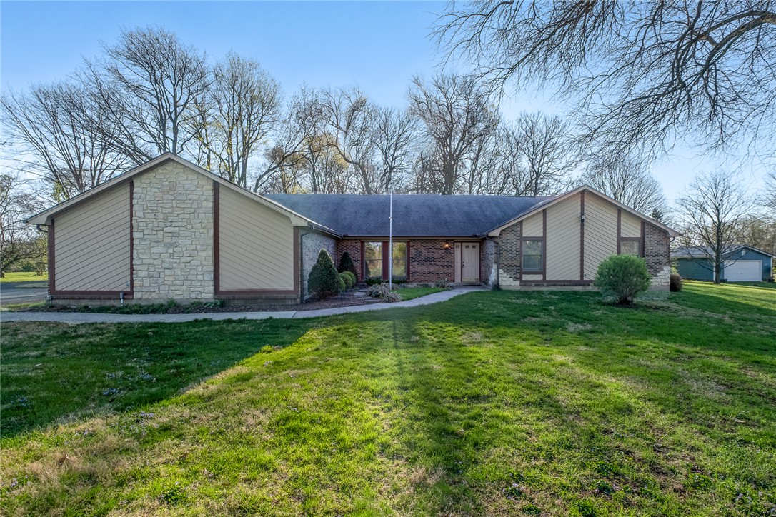 This property features a harmonious blend of brick and stone with mature trees.