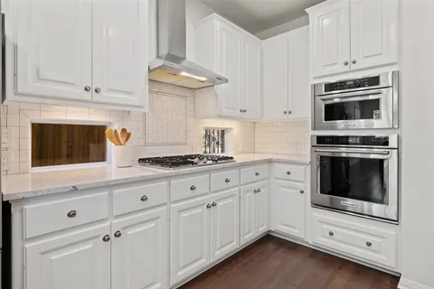 a kitchen with granite countertop white cabinets stainless steel appliances and sink