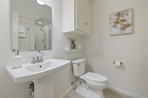 a bathroom with a sink mirror and toilet