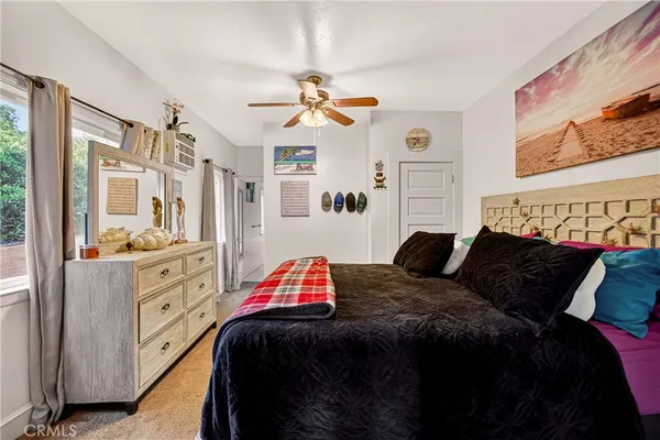 a bedroom with a bed a chair and a large window