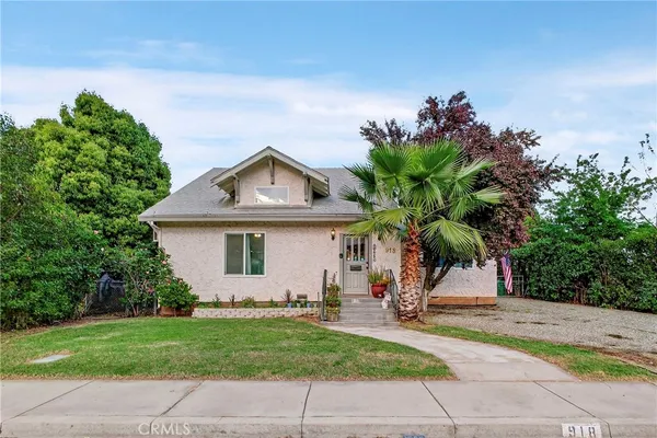 a front view of a house with a tree
