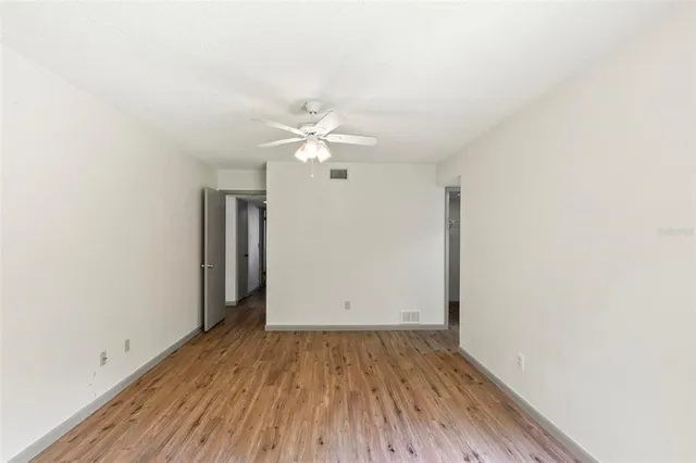 an empty room with wooden floor and window
