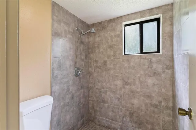 a bathroom with a toilet and a shower