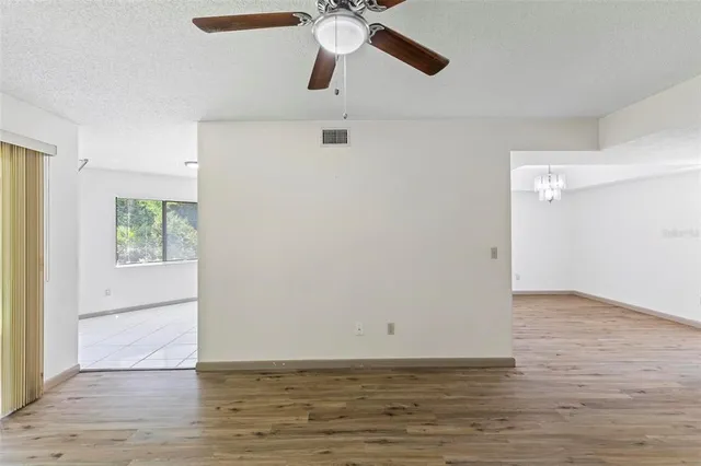 a view of an empty room with window and wooden floor