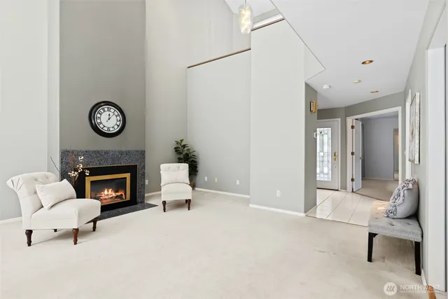 a living room with furniture a fireplace a clock and a fireplace