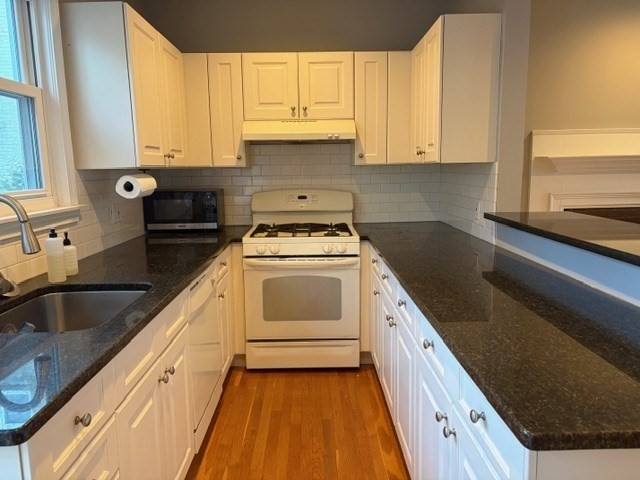 a kitchen with a sink stove and cabinets