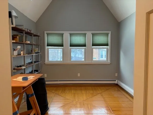 a view of a room with wooden floor and a window