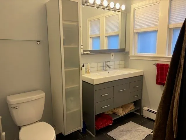a bathroom with a toilet sink and mirror