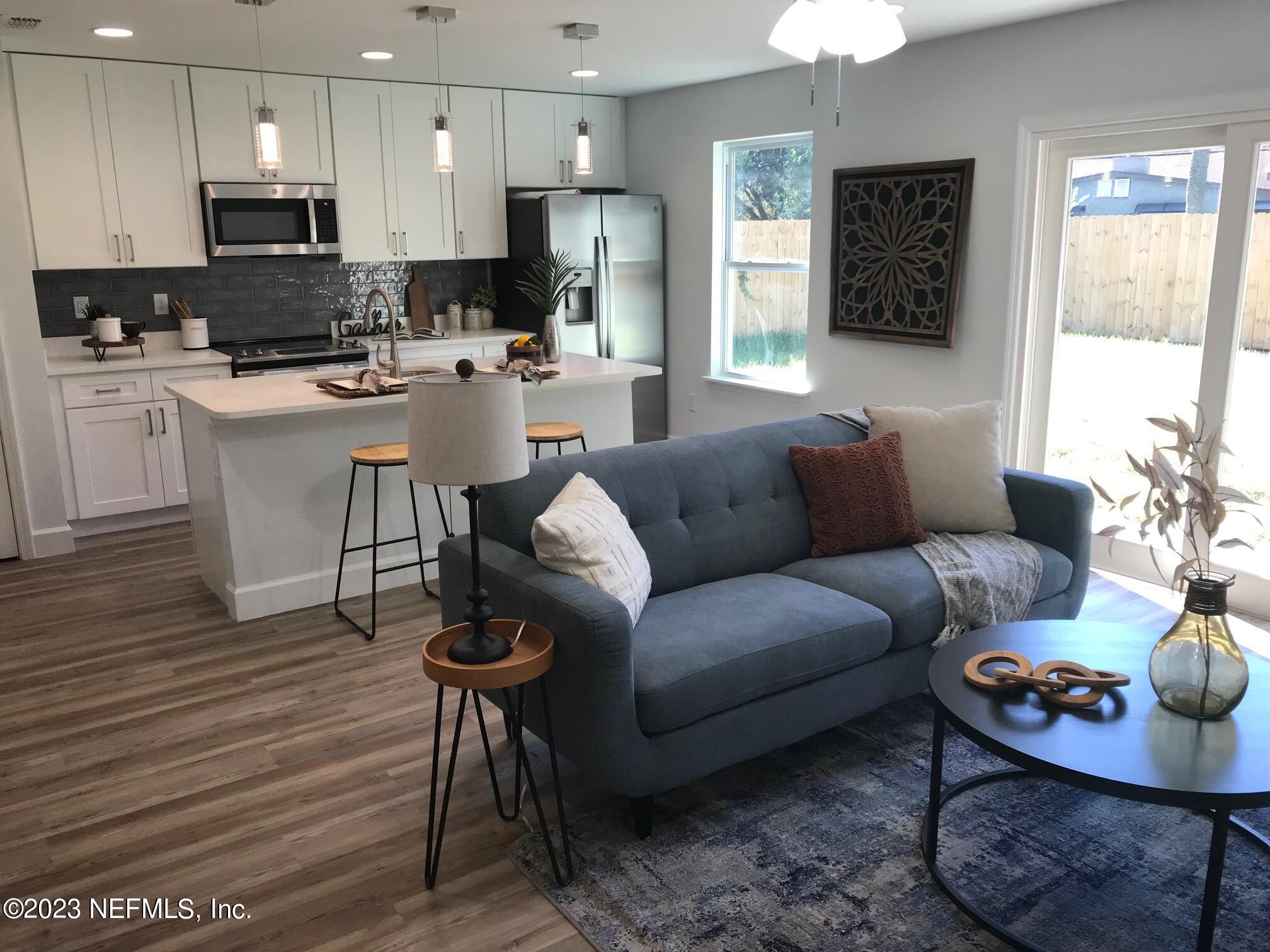 3748 Foxcroft Road Jacksonville, FL 32257 - Photo 12 of 33 a living room with furniture a refrigerator and kitchen view
