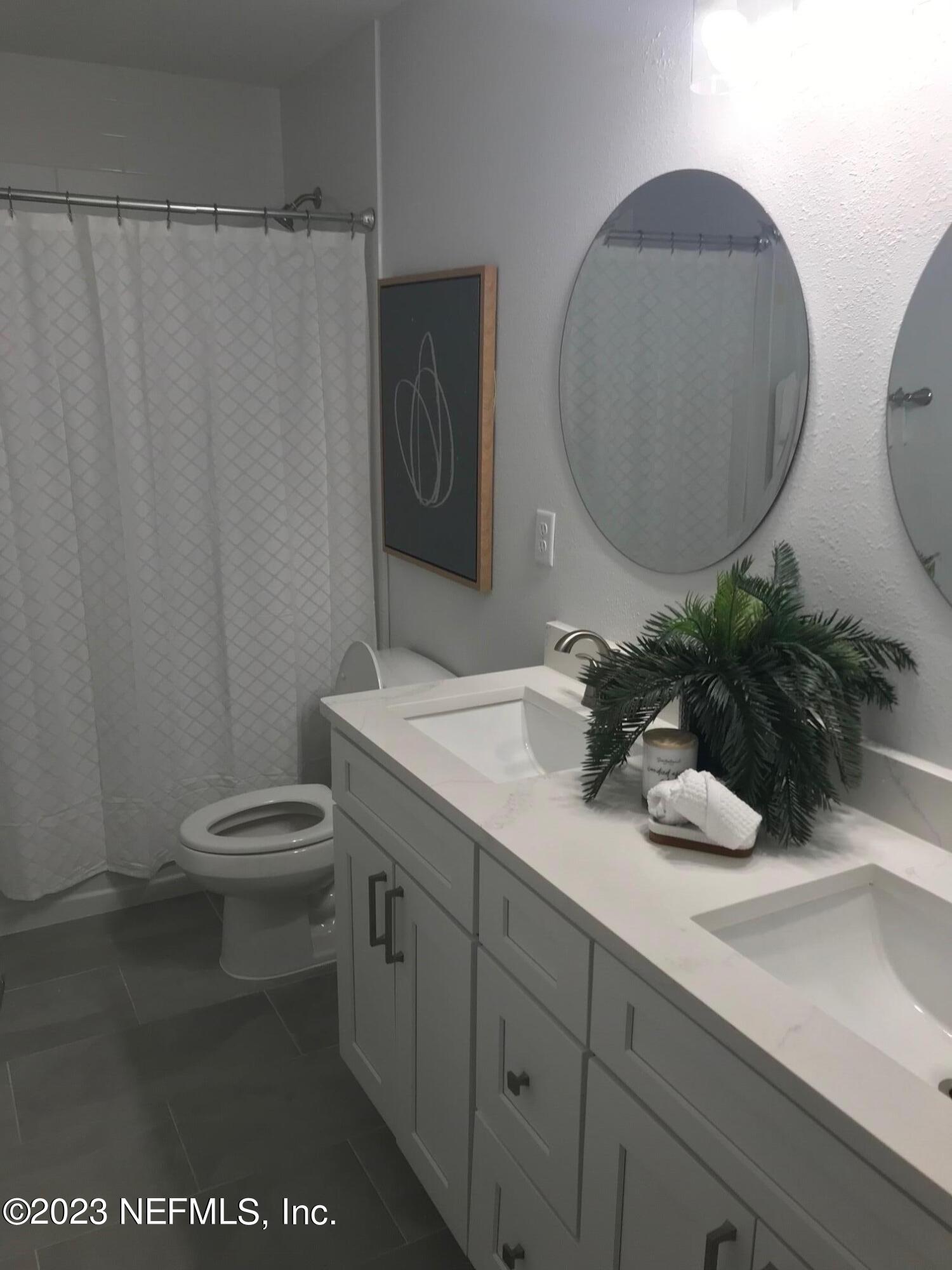 3748 Foxcroft Road Jacksonville, FL 32257 - Photo 23 of 33 a bathroom with a granite countertop sink a toilet and a mirror