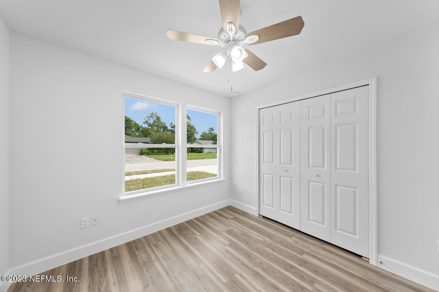 3748 Foxcroft Road Jacksonville, FL 32257 - Photo 28 of 33 an empty room with wooden floor chandelier fan and windows