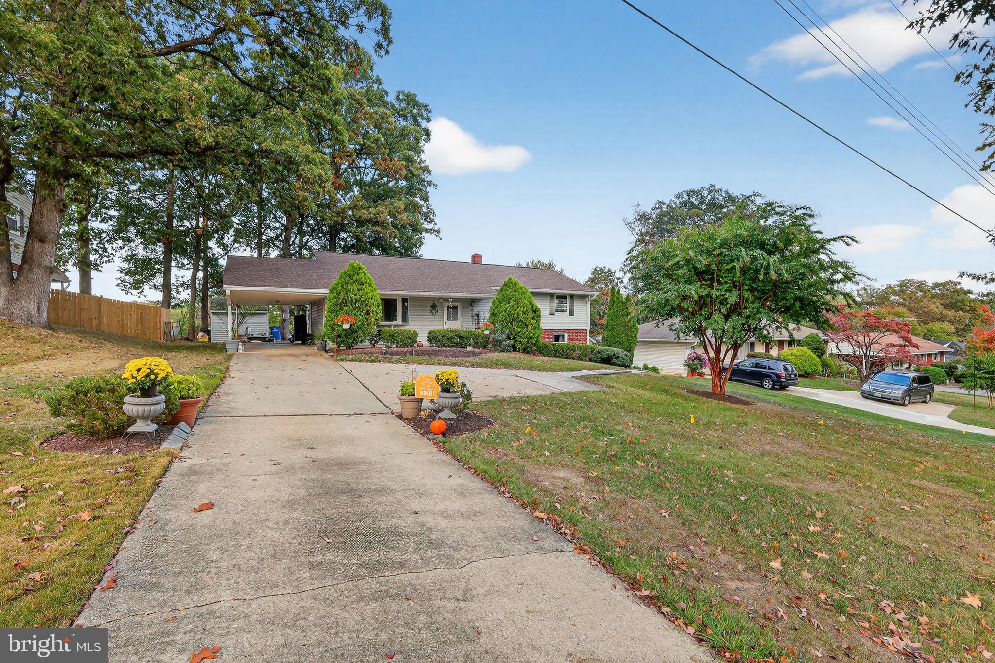 a view of a white house with a yard and potted plants