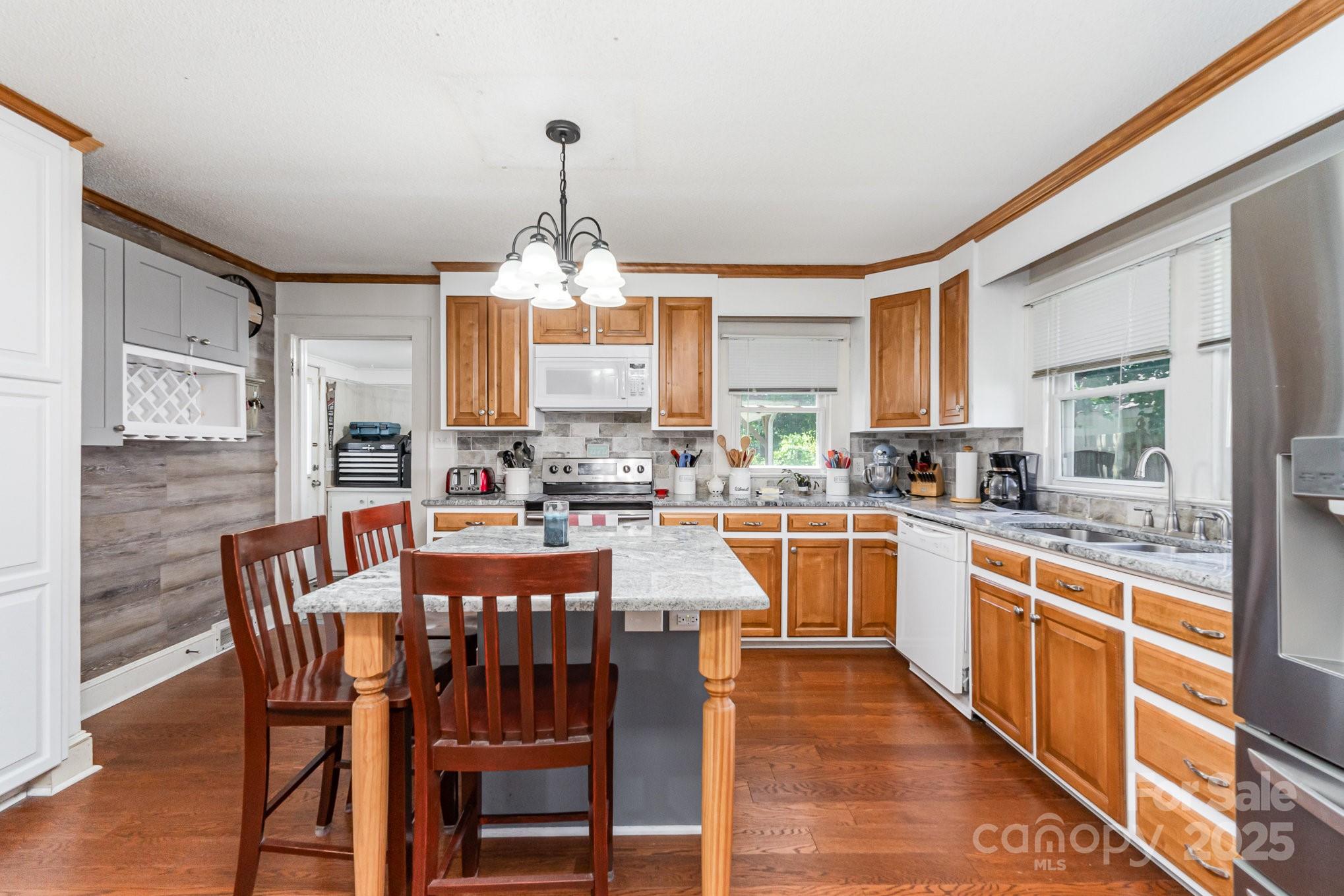 1306 Brantley Road Kannapolis, NC 28083 - Photo 11 of 29 a kitchen with stainless steel appliances granite countertop a stove top oven a sink dishwasher a dining table and chairs with wooden floor