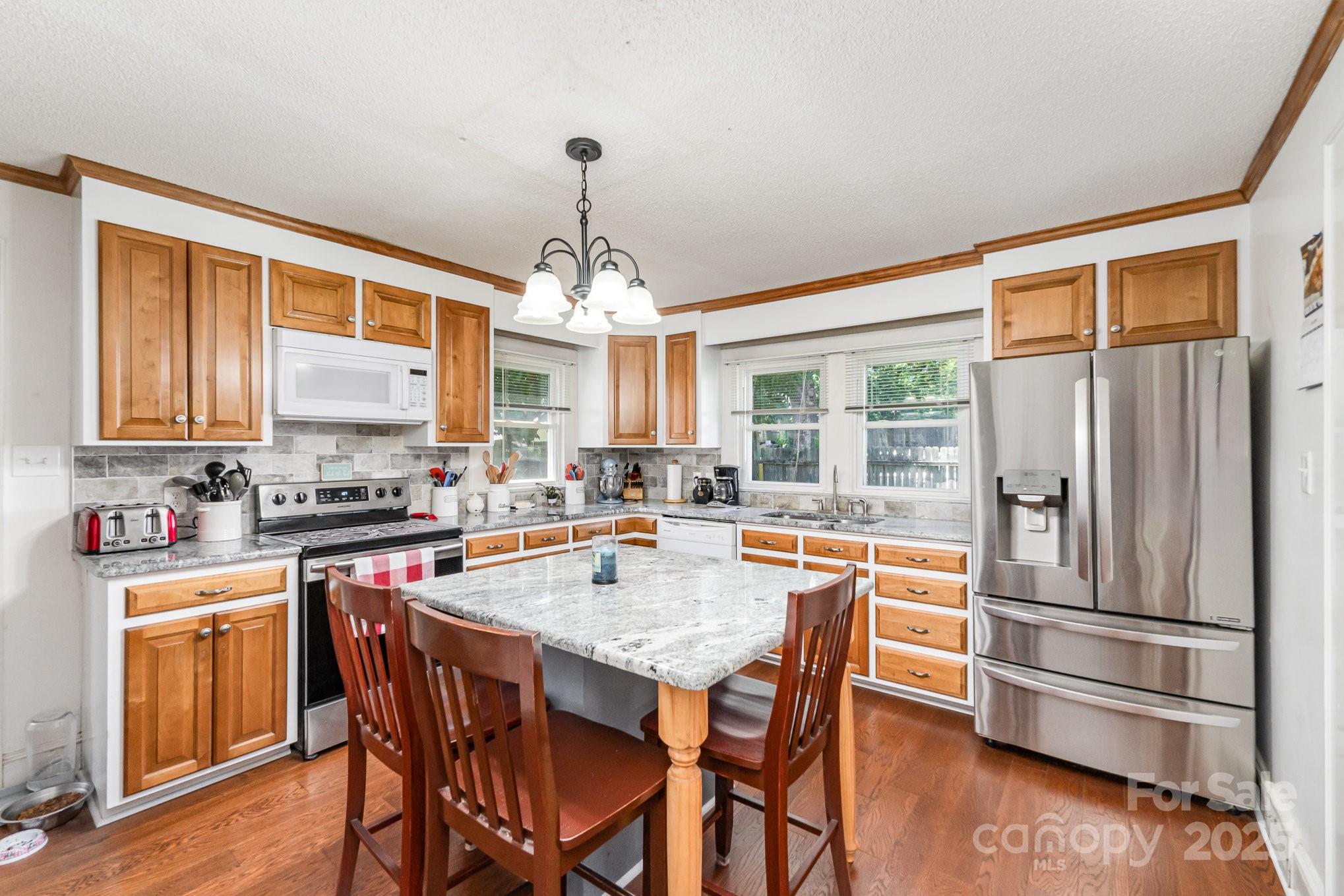 1306 Brantley Road Kannapolis, NC 28083 - Photo 13 of 29 a kitchen with stainless steel appliances a dining table and chairs
