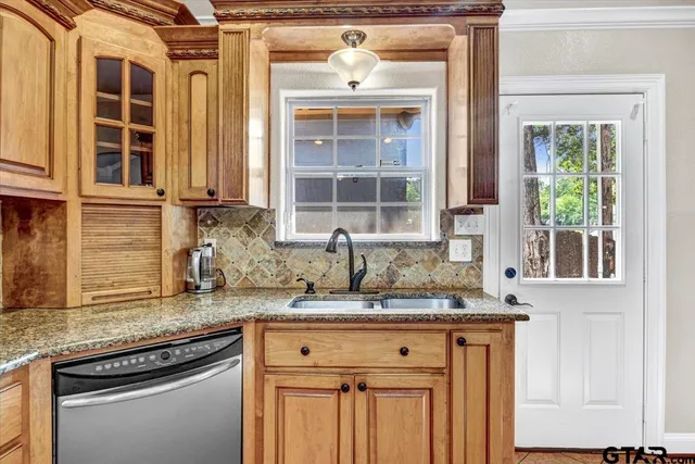 a kitchen with granite countertop a sink stove and cabinets