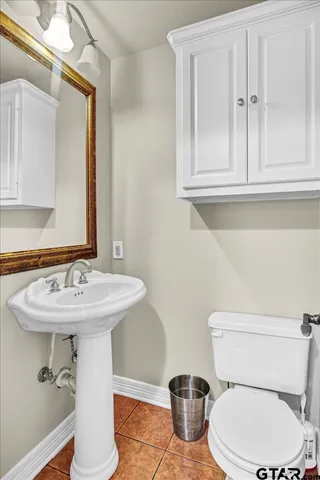 a bathroom with a toilet a sink and mirror